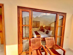 een kamer met een raam, 2 stoelen en een slaapkamer bij Mountain view in Mussoorie