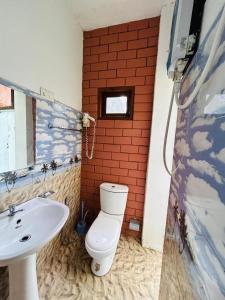 a bathroom with a toilet and a sink at Milkyway Holiday Resort in Unawatuna