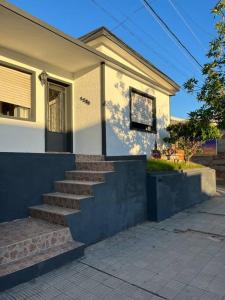 ein Haus mit einer Treppe davor in der Unterkunft María Chusena alojamiento 1 in Fray Bentos