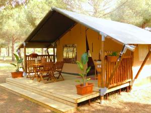 a tent with a table and chairs on a deck at Mecca Club in Ischitella