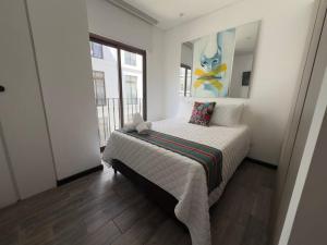 una camera da letto con un letto e un dipinto sul muro di L1C 301 - Boutique apartment in Cayala for 4 guests a Guatemala