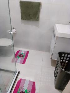 - une salle de bains avec des tapis roses et verts au sol dans l'établissement Canto do sol, à Cabo Frio