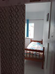 - une chambre avec un lit dans une pièce dotée d'une fenêtre dans l'établissement Canto do sol, à Cabo Frio