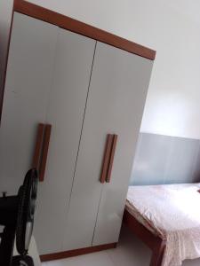 - une chambre avec une armoire blanche à côté d'un lit dans l'établissement Canto do sol, à Cabo Frio