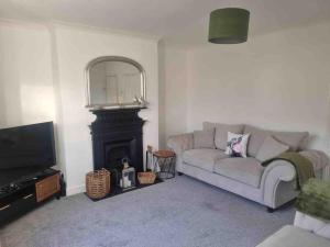 a living room with a couch and a fireplace at 2 Bedroom Cosy Cottage in Rearsby