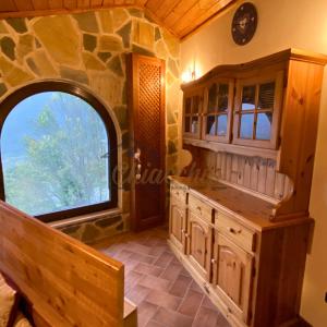 a kitchen with a large window and a stone wall at La Baita sulla Neve - Posto Auto in Rocca Cinquemiglia