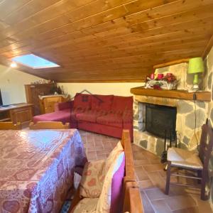 a living room with a fireplace and a couch at La Baita sulla Neve - Posto Auto in Rocca Cinquemiglia