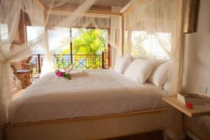ein Schlafzimmer mit einem weißen Bett mit Blumen darauf in der Unterkunft Amazing 6 BR Ocen View Villa in Marigot Bay in Marigot-Bucht