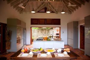 eine Küche mit Tisch und Schüsseln mit Essen drauf in der Unterkunft Amazing 6 BR Ocen View Villa in Marigot Bay in Marigot-Bucht