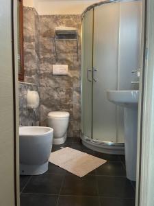uma casa de banho com um chuveiro, um WC e um lavatório. em B&B Villa Magna Grecia em Lazzaro