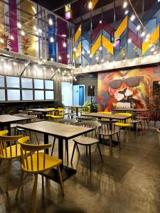 a restaurant with tables and chairs and a large mural at Coliwo Trois - Kharadi in Pune