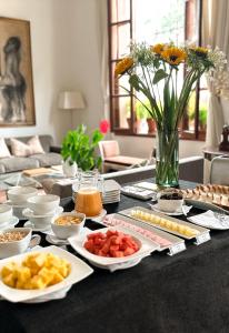 un tavolo con piatti di cibo e un vaso di fiori di El Golf Hotel Boutique a Lima