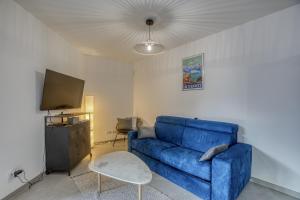 een woonkamer met een blauwe bank en een tv bij View Point Semnoz in Annecy