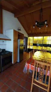 a kitchen with a table and a stove and a refrigerator at Chalet en Miramar (Calle 35 n°1043) in Miramar +16 photos