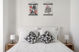 a white bed with two pillows on top of it at Ajuda Charm Apartment with Garden in Lisbon