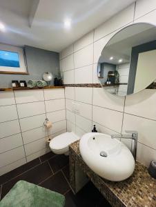 ein Bad mit einem Waschbecken und einem Spiegel in der Unterkunft Ferienwohnung Palatina in Heuchelheim-Klingen