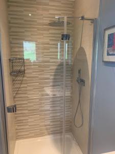 eine Dusche mit Glastür im Bad in der Unterkunft The Coach House in Warnham