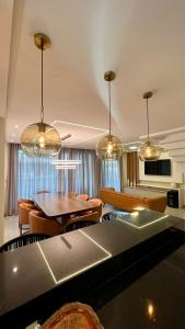 ein Wohnzimmer mit einem Tisch, Stühlen und Kronleuchtern in der Unterkunft Casa em Maragogi/AL in Maragogi