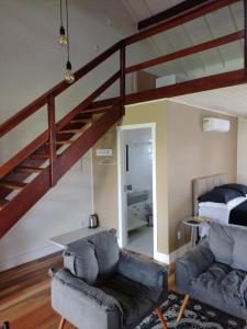a living room with a staircase and a couch and a bed at Pousada Toscana Cambará in Cambara do Sul