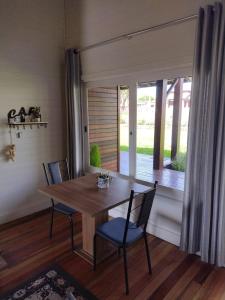 a dining room with a table and chairs and a window at Pousada Toscana Cambará in Cambara do Sul