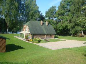 a barn with a green roof on a lawn at Brīvdienu māja Ezerlīči in Korneti