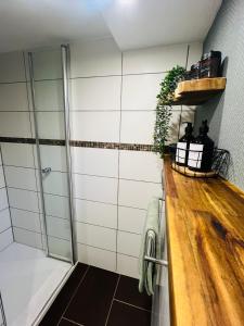 ein Bad mit einer Dusche und einer Holztheke in der Unterkunft Ferienwohnung Palatina in Heuchelheim-Klingen