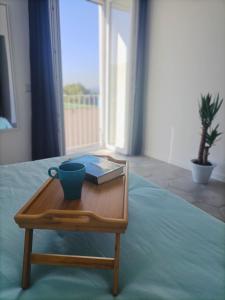 - une table basse avec un livre et une tasse sur un lit dans l'établissement Casalulù Holiday Home - Lovely Apartment Sorrento Coast, à Vico Equense