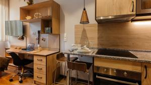 a kitchen with a counter and a desk with a laptop at Livensa Living Studios San Sebastián in San Sebastián