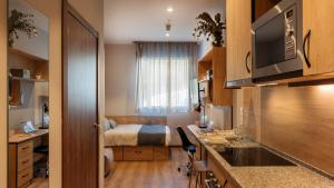 a small room with a bed and a kitchen at Livensa Living Studios San Sebastián in San Sebastián