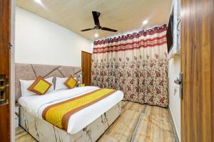 1 dormitorio con cama y cortina en Hotel Mini Residency - Hari Nagar Ghanta Ghar en Nueva Delhi