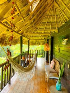 a porch with a hammock on a deck at Villa Tayrona in El Zaino