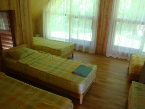 KornetiにあるBrīvdienu māja Ezerlīčiの窓付きのキャビン内のベッド3台が備わる客室です。