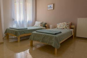 a room with two beds and a chair at Kalimera Apartment in Kavála