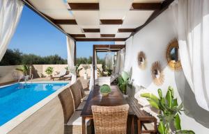 a patio with a table and chairs next to a swimming pool at Villa Elisabeth View in Platanias
