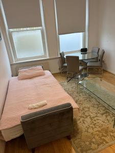 a bedroom with a bed and a table and chairs at Property minutes from Hammersmith and Kensington 2 in London