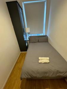 a bed with two towels on it in a small room at Property minutes from Hammersmith and Kensington 2 in London