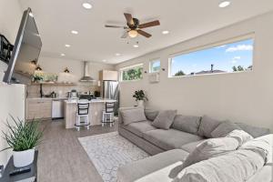 a living room with a couch and a kitchen at Beautiful Denver Carriage House in Denver