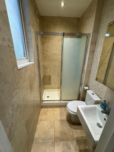 a bathroom with a shower and a toilet and a sink at Property minutes from Hammersmith and Kensington 2 in London