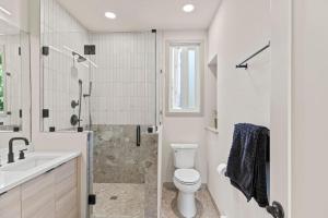 a white bathroom with a toilet and a shower at Beautiful Denver Carriage House in Denver