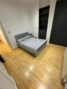 a bedroom with a bed and a wooden floor at Property minutes from Hammersmith and Kensington 2 in London