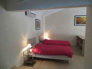 1 dormitorio con 1 cama con manta roja en Domaine de Cassan, en Lafare