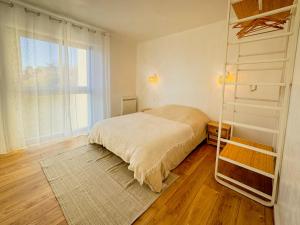 um quarto com uma cama e uma grande janela em Le Cocon La Boétie em Périgueux