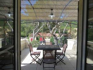 einen Tisch und Stühle auf einer Terrasse mit einem Baum in der Unterkunft Domaine de Cassan in Lafare