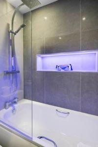 a bathroom with a shower and a bath tub at Miramont - Poolside Apartment 