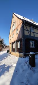 a large wooden building with snow on the ground at Flachshäusl in Mittelndorf
