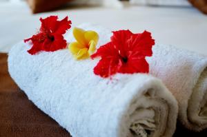 a towel with flowers on it on a bed at Nyuh Gading Home Stay in Nusa Lembongan +49 photos