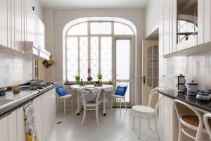 uma cozinha branca com uma mesa e cadeiras em Villa Don Guglielmo AMALFI COAST em Ravello