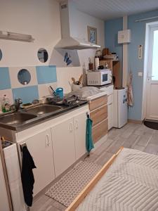 a kitchen with a sink and a microwave at Entre terre et mer in Gémozac