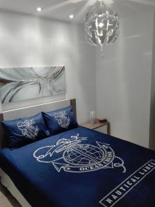 a bedroom with a bed with blue sheets and a chandelier at Seixal Yachting Bay Apartments in Seixal