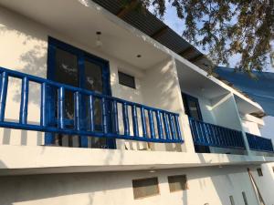 a white house with a blue balcony at Áncora Beach Hotel in Máncora